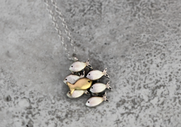 Small Swimming against the current necklace. Dainty silver necklace. School of fish with one gold fish swimming upstream.